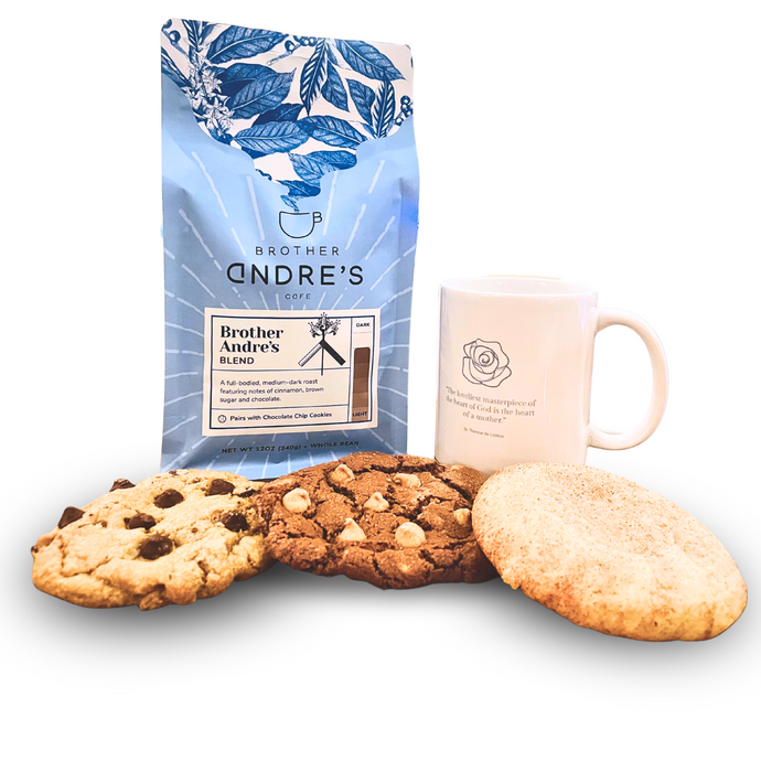 Brother Andre's coffee gift set displayed with a blue-packaged blend roast coffee, three fresh-baked cookies (chocolate chip, chocolate peanut butter, and snickerdoodle), and a ceramic mug.